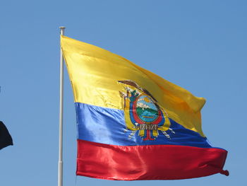 Low angle view of flag against blue sky