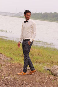 Full length of young man walking on land against lake