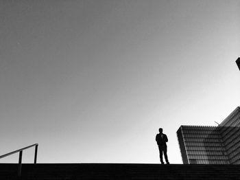 Low angle view of silhouette woman against clear sky