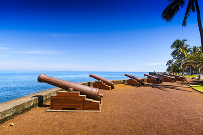 Lifeguard hut on beach against blue sky