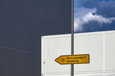 Information sign against wall in city