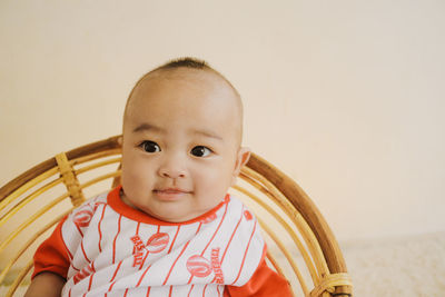 Portrait of cute baby boy against white background