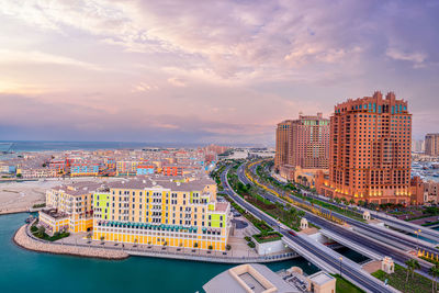 High angle view of city by sea against sky