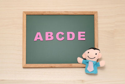 High angle view of blackboard with alphabets and toys on table
