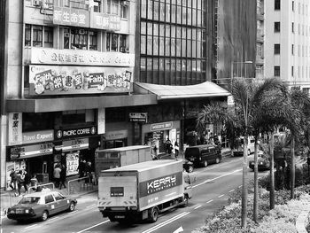 Cars on road by buildings in city