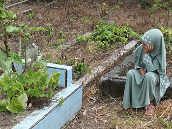 Woman sitting in a cemetery