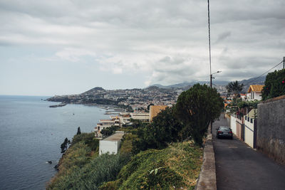 High angle view of townscape by sea against sky