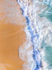 High angle view of waves rushing towards shore