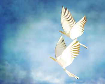 Low angle view bird shape kits flying against sky