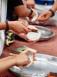 Midsection of man holding ice cream on table