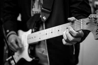 Midsection of man playing guitar