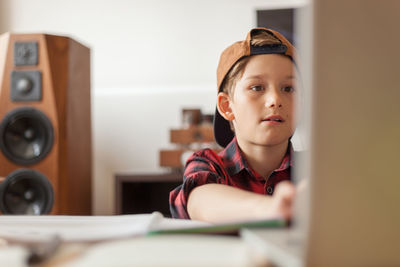 Portrait of boy sitting on book at home
