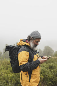 A man catches the signal on his mobile phone while looking for interesting places in the mountains