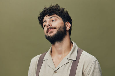 Young man looking away against gray background