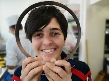 Portrait of smiling woman holding circular picture frame