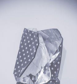 Close-up of paper wrapped over white background