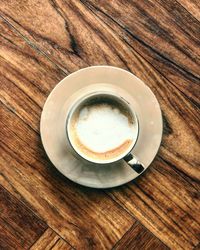 High angle view of coffee cup on wooden table