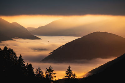 Scenic view of silhouette mountains against sky during sunset