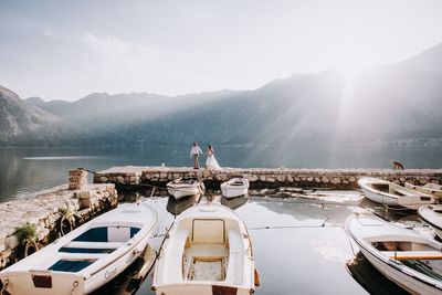 People on boat in lake against mountains