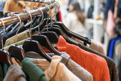 Clothes on coat hangers and shelves in a store.