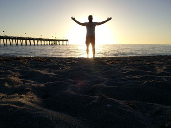 Silhouette of woman on beach at sunset