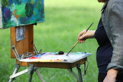 Midsection of man holding plastic bag midsection of person holding multi colored umbrellas painter, 