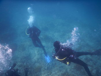 Low angle view of people swimming in sea