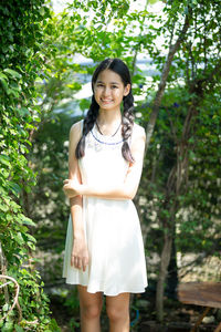 Portrait of smiling girl standing against plants