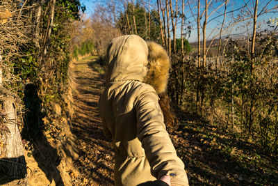 Cropped image of man holding woman hand on footpath