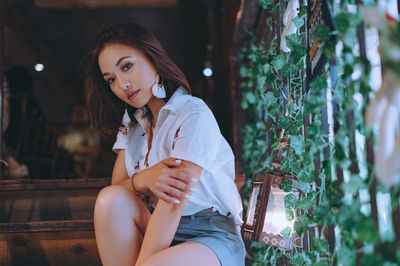 Portrait of young woman sitting outdoors