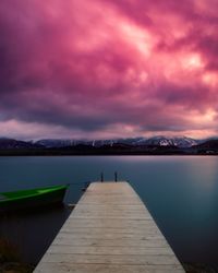 Pier over lake against sky during sunset