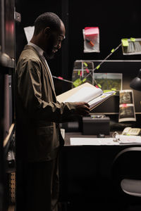 Rear view of man using digital tablet in office