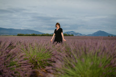 Woman standing on land against sky