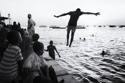 People at beach against sky