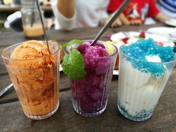Close-up of various ice creams in glasses on table
