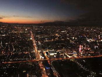 High angle view of illuminated city against sky at night