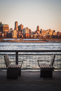 View of river and buildings against sky during sunset