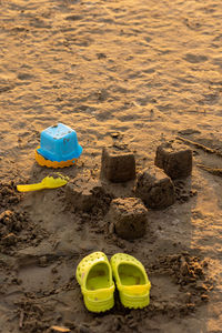 Children's yellow sandals on the beach