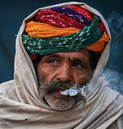 Close-up of man looking away while emitting smoke