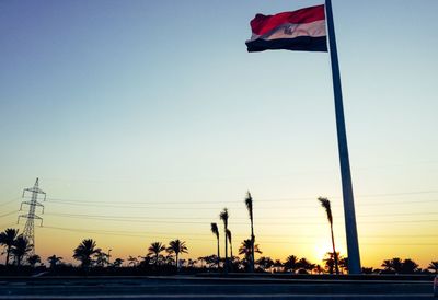 Low angle view of flags against clear sky during sunset