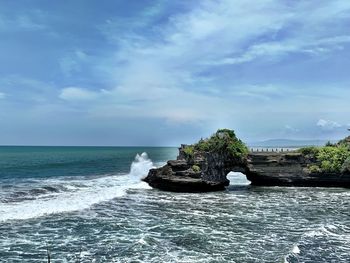 Rock formation in sea against sky