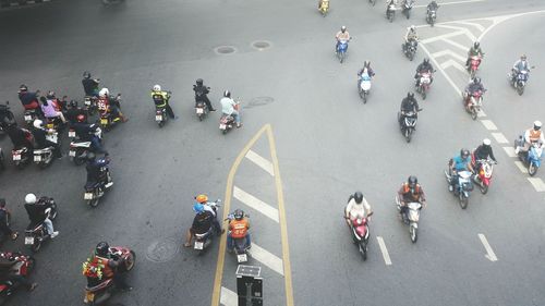 High angle view of people with motorcycles on road in city