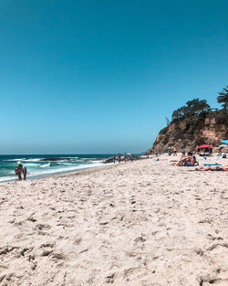 Scenic view of beach against clear blue sky