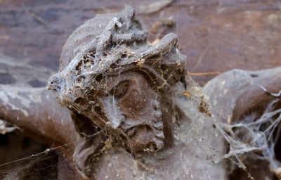 Low angle view of spider web on abandoned old jesus christ statue