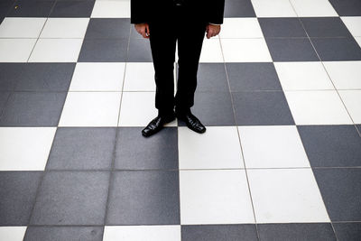 Low section of woman standing on tiled floor