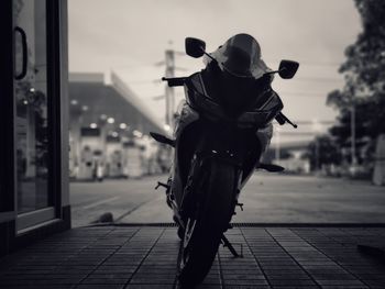 Motorcycle on footpath against sky