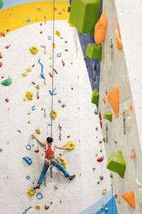 Low angle view of woman climbing on wall