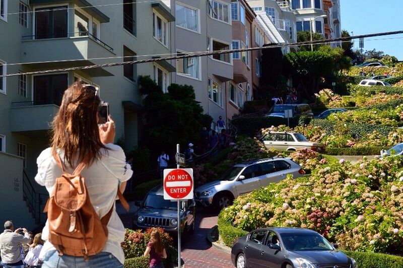 lifestyles, young adult, leisure activity, casual clothing, building exterior, person, architecture, land vehicle, transportation, built structure, car, mode of transport, young women, standing, smiling, street, three quarter length, city