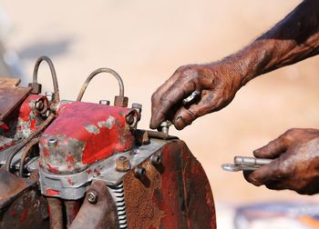 Close-up of man working on rusty metal