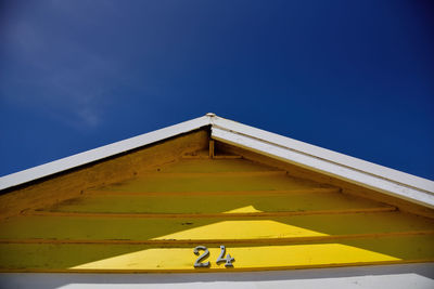 Low angle view of yellow bridge against blue sky